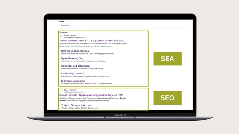 Ein MacBook Air zeigt auf seinem Bildschirm eine Google-Suchergebnisseite. Hervorgehoben sind zwei Suchanzeigen bzw. Einträge für "Second Elements".