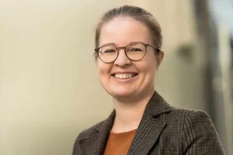 Porträt einer digitalen Strategin der Agentur Second Elements mit Brille und Blazer – spezialisiert auf Performance Marketing und Online-Sichtbarkeit.